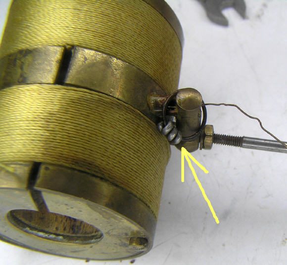 A string of small lead weights hidden behind the coil cover of a Bulle pendulum